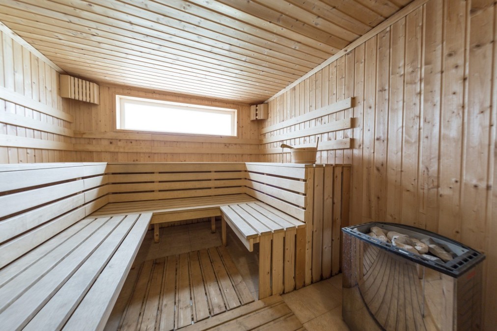 Wooden sauna with tiered benches, used for recovery during sports training camp