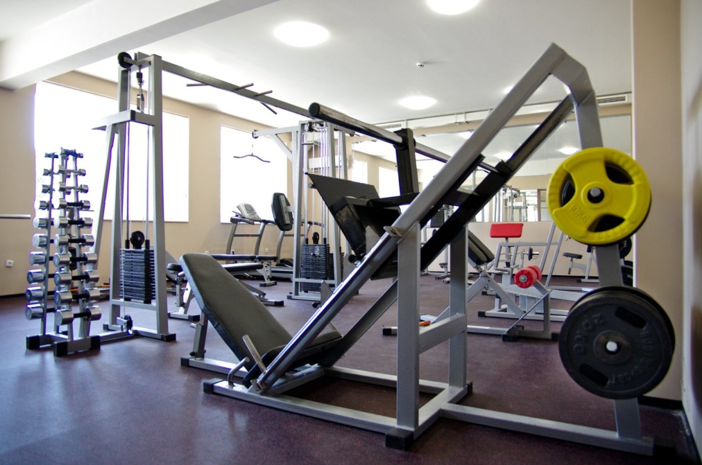 Weight training room with machines, barbells, and plates for athlete workout sessions