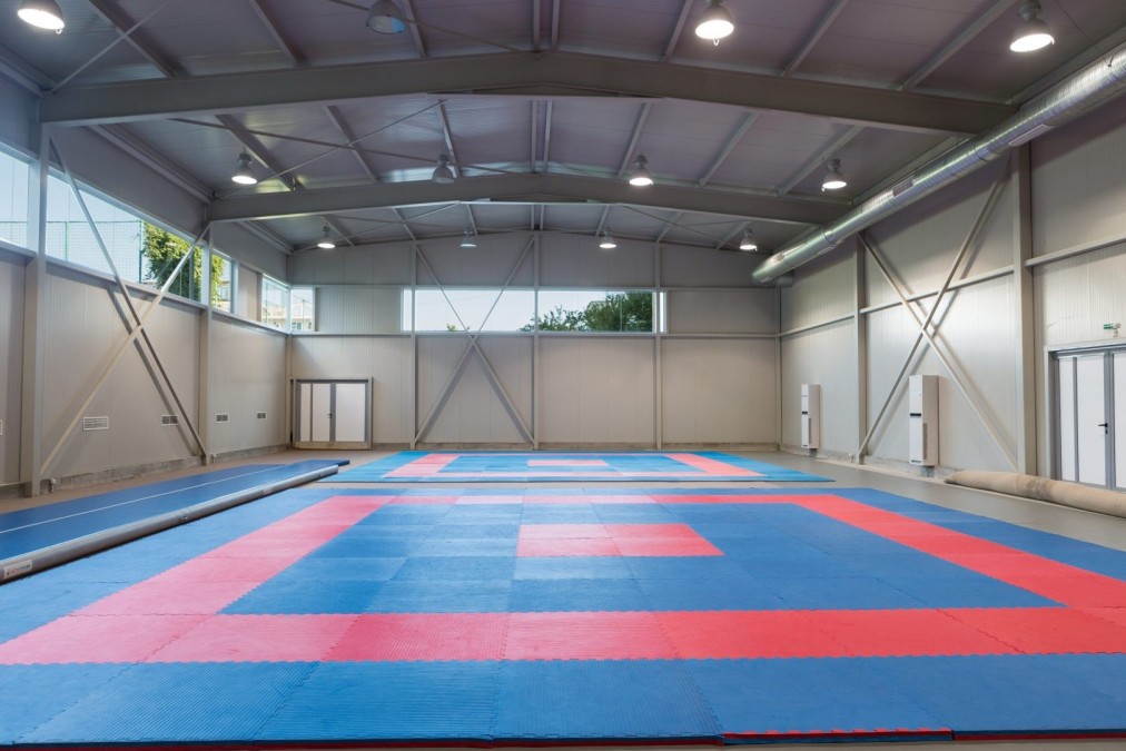 Indoor training hall with red and blue mats, prepared for martial arts or gymnastics training camp