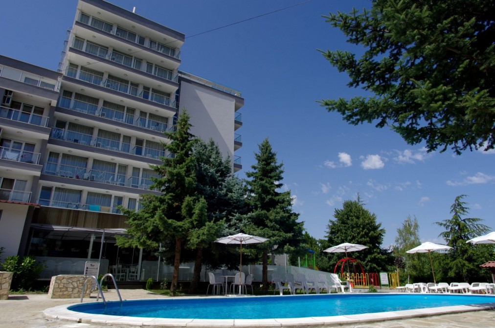 Outdoor hotel pool beside multi-story building, used for recovery swims during training camp