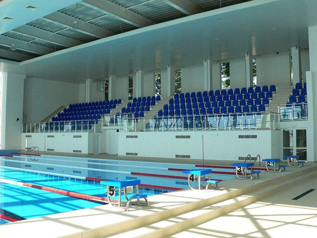 Indoor pool with spectator stands and starting blocks
