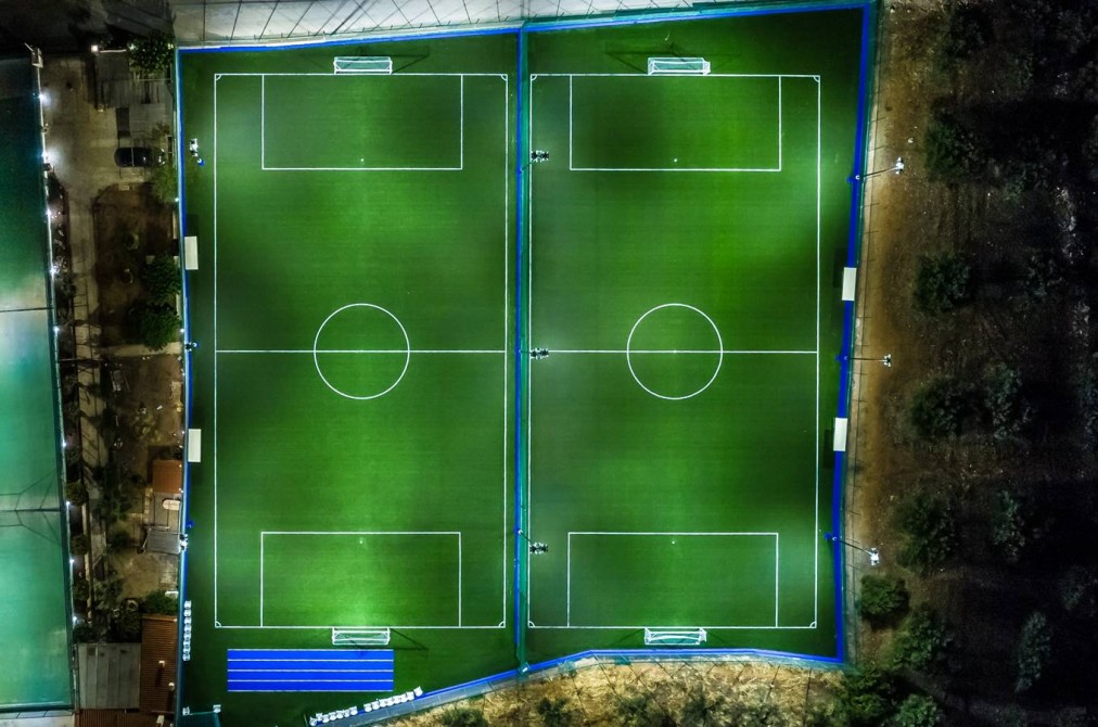 Floodlit football pitches, night aerial view