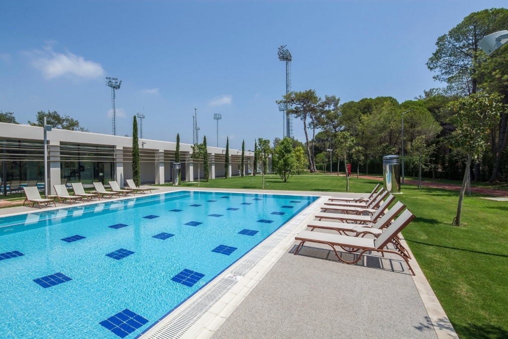 Outdoor swimming pool with sun loungers and lane markers