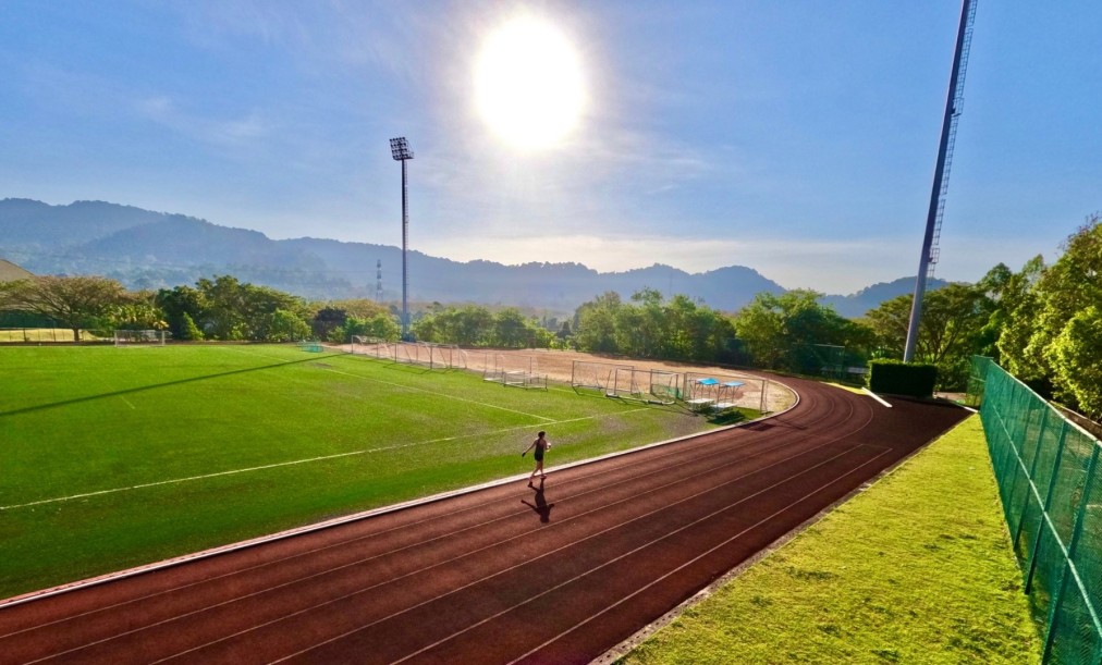 Natural grass football pitch bordering the running track