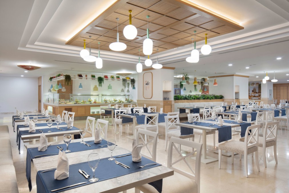 Restaurant dining hall with buffet counters and set tables.