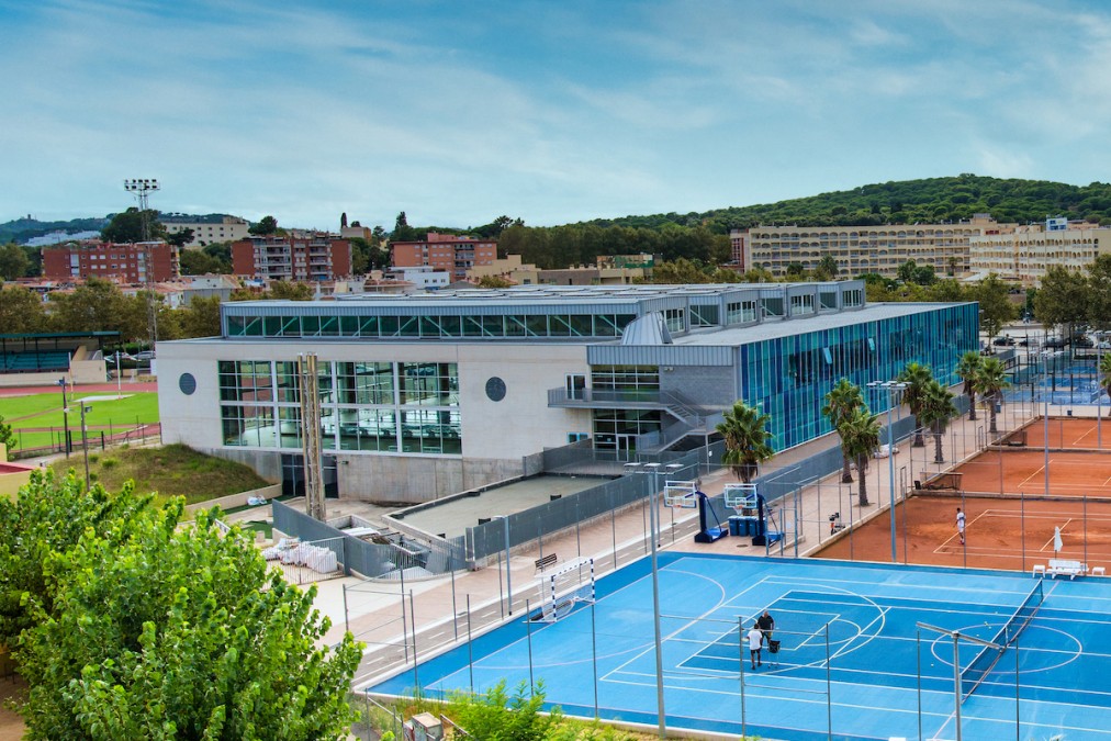 Sports complex with pool, track and courts, aerial view
