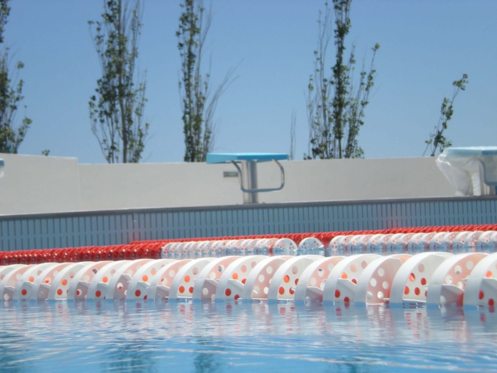 Lane ropes and a starting block at an outdoor swimming training pool.