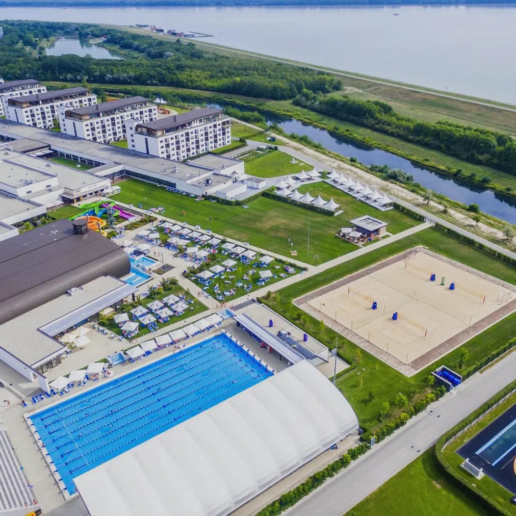 Sports resort overview with pools and courts, aerial view