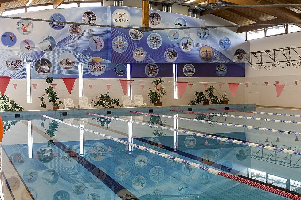 Indoor pool with lane ropes and mural wall