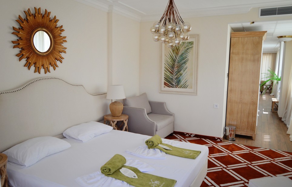 Room with sunburst mirror, folded towels