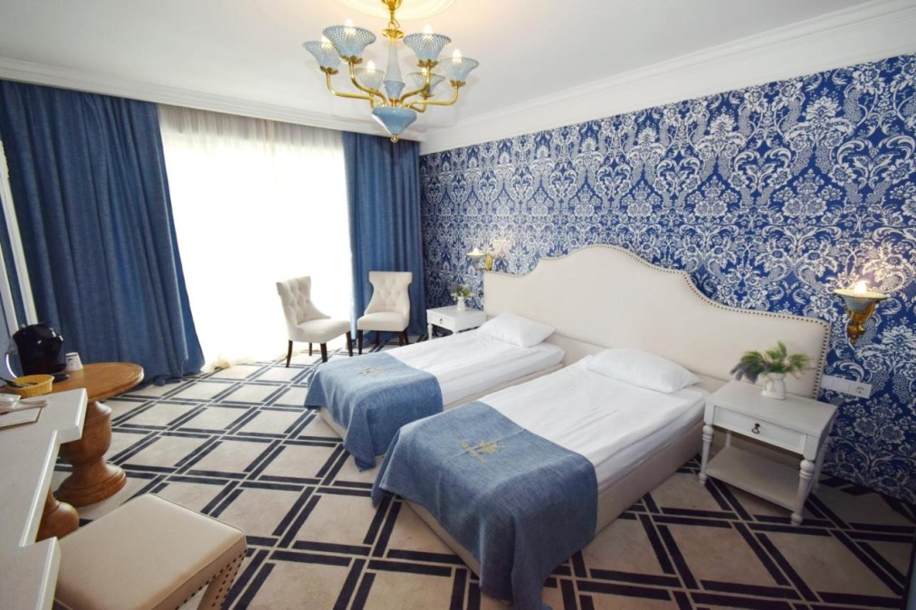 Twin room with blue drapes and chandelier