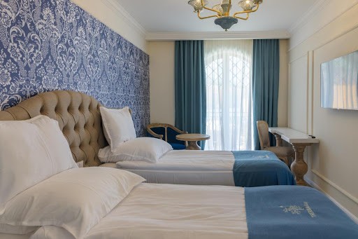 Twin room with blue damask wallpaper