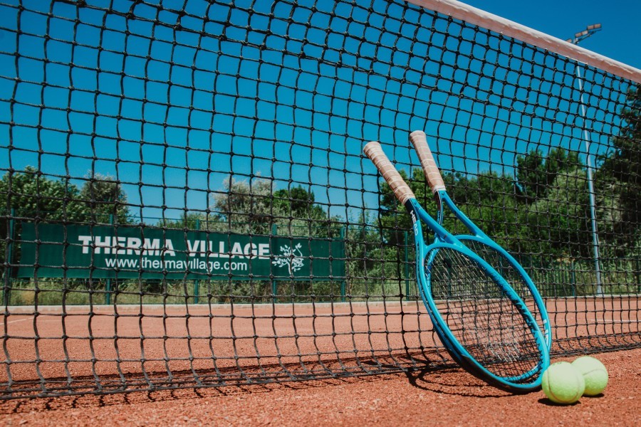 Tennis racket and balls at the net