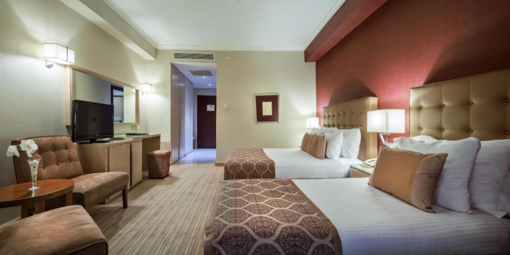 Twin room with two beds, seating area, and TV