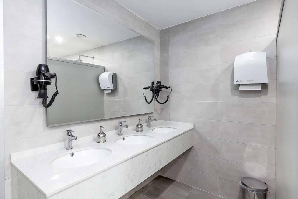 Restroom with sinks, mirrors, and hair dryers