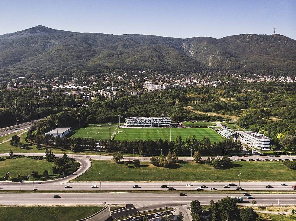 Wide aerial view of football fields, hotel buildings, and surrounding roads, used for team training camps