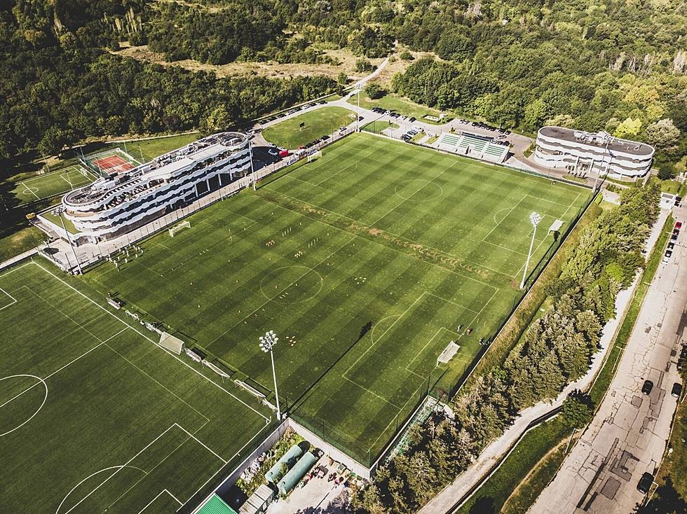 Overhead view of a full-size soccer stadium and adjacent training fields, prepared for practice sessions