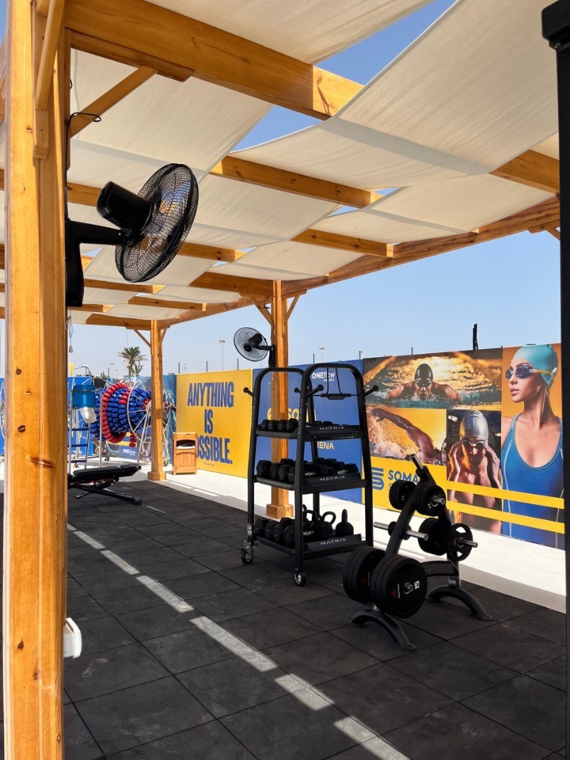 Outdoor training area with shaded equipment and sports facility branding