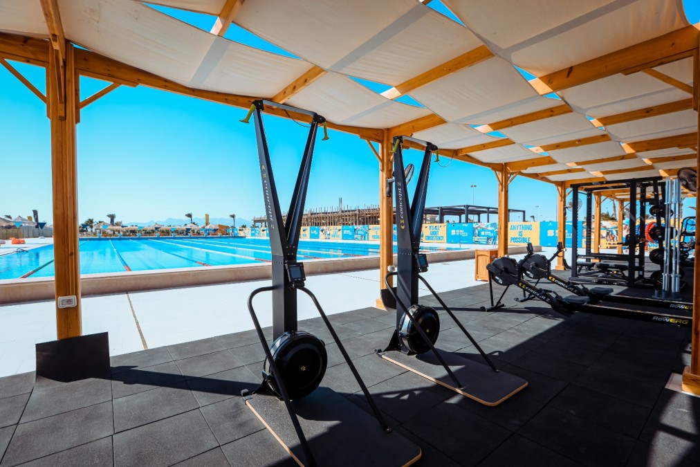 Outdoor gym area — SkiErg machines, rowing machines, squat rack