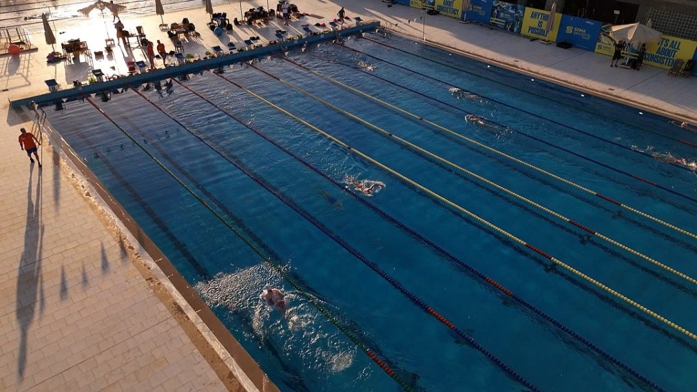 50m outdoor pool during a training session — angled aerial view