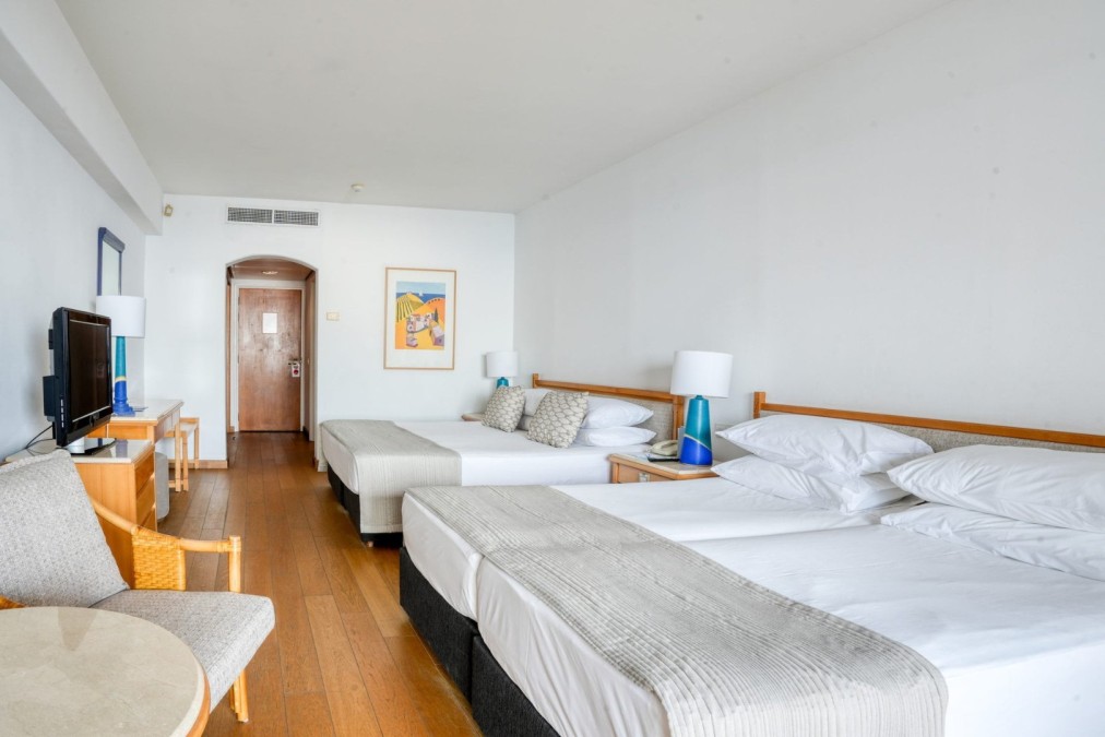 Spacious hotel room with multiple beds and wooden furniture for team accommodations