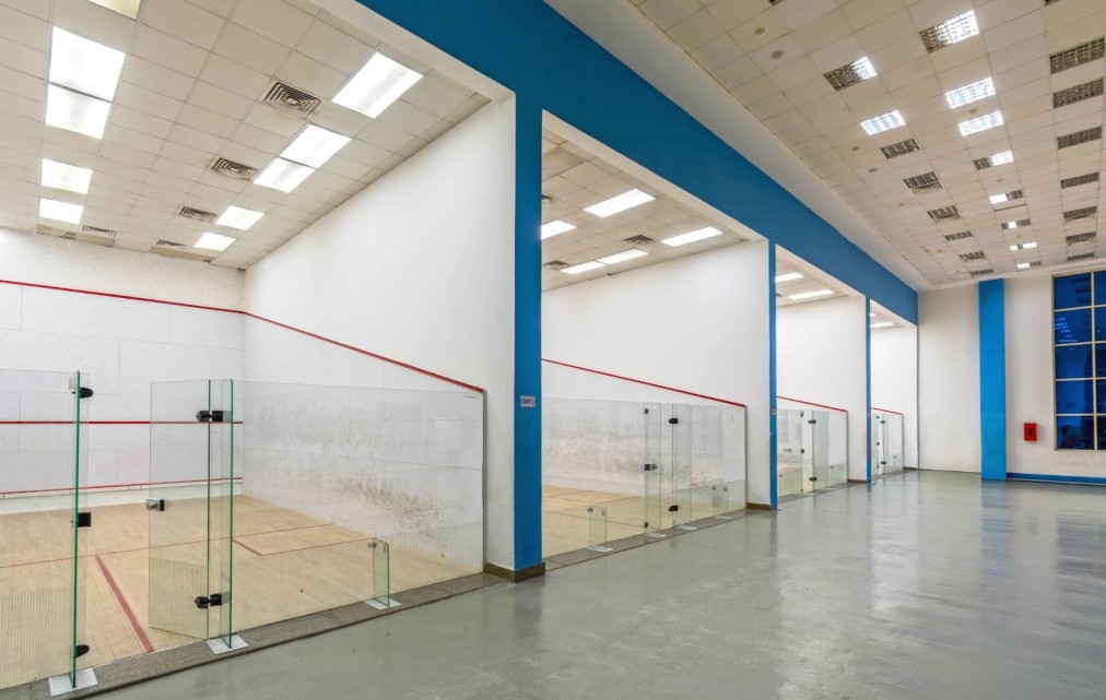 Side view of the court row with glass enclosures and wooden playing surface