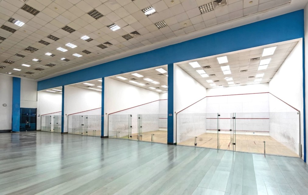 3 courts viewed from the corridor with tiled floor and panel ceiling lighting
