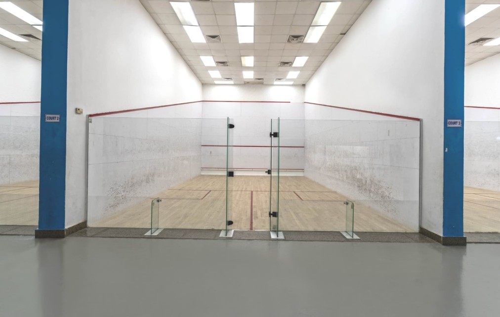 Single court interior: wooden floor, red line markings and glass back wall