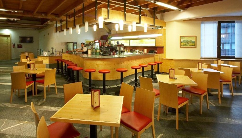 Restaurant lounge with bar counter, high stools, and dining tables.