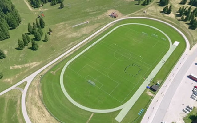 Aerial view of football pitch inside an oval running track.