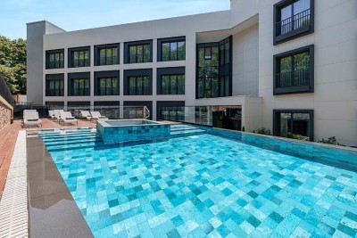 Outdoor swimming pool in the hotel courtyard with sun loungers and terrace seating.