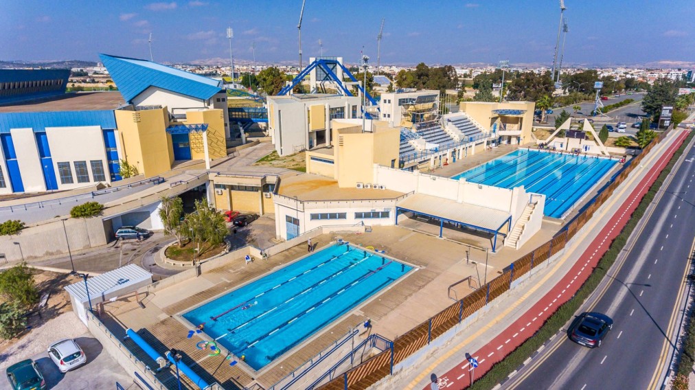 Aerial view of pools, grandstand and adjacent sports buildings.