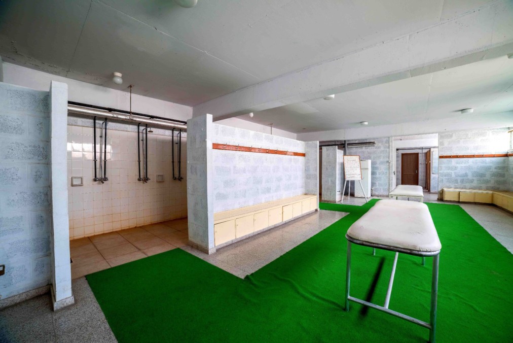 Recovery room with showers, treatment tables and bench seating.