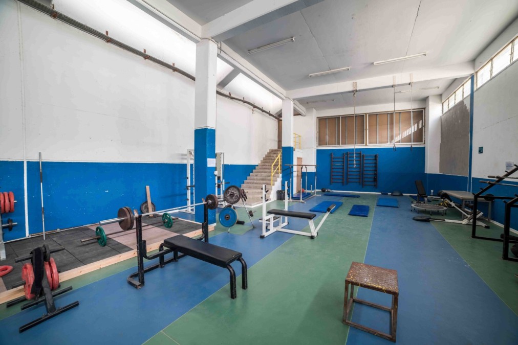 Strength training hall with benches, barbells and lifting platforms.