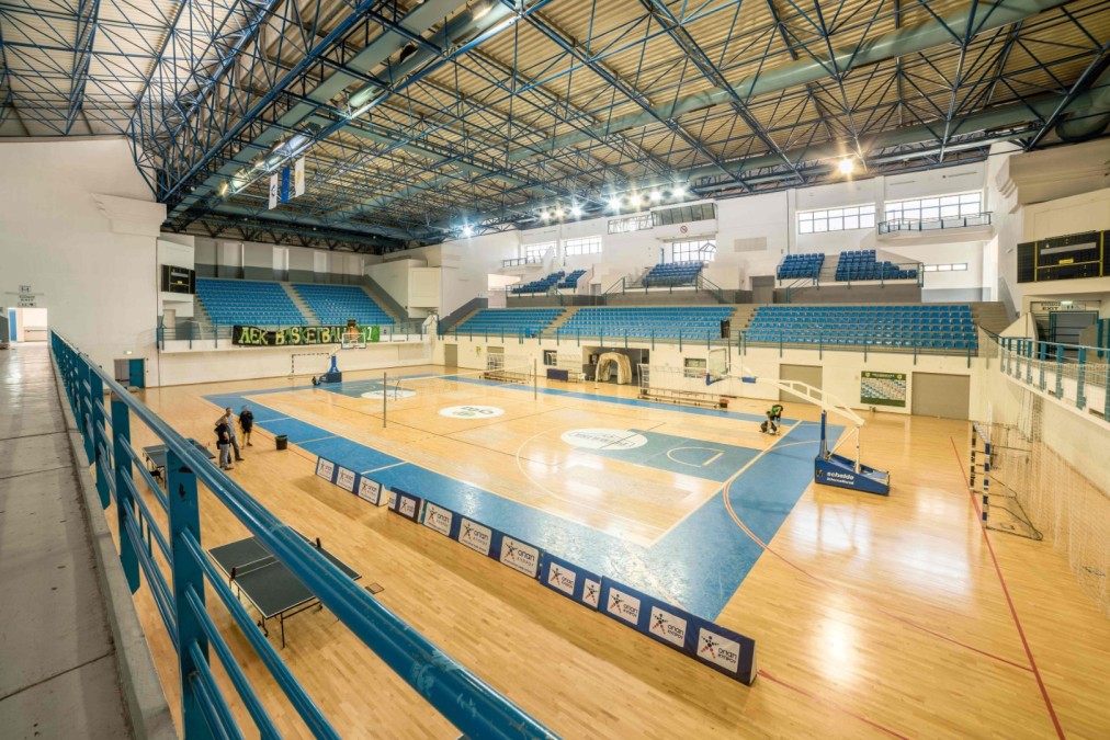 Indoor sports hall viewed from the upper tier with multi-use court below.