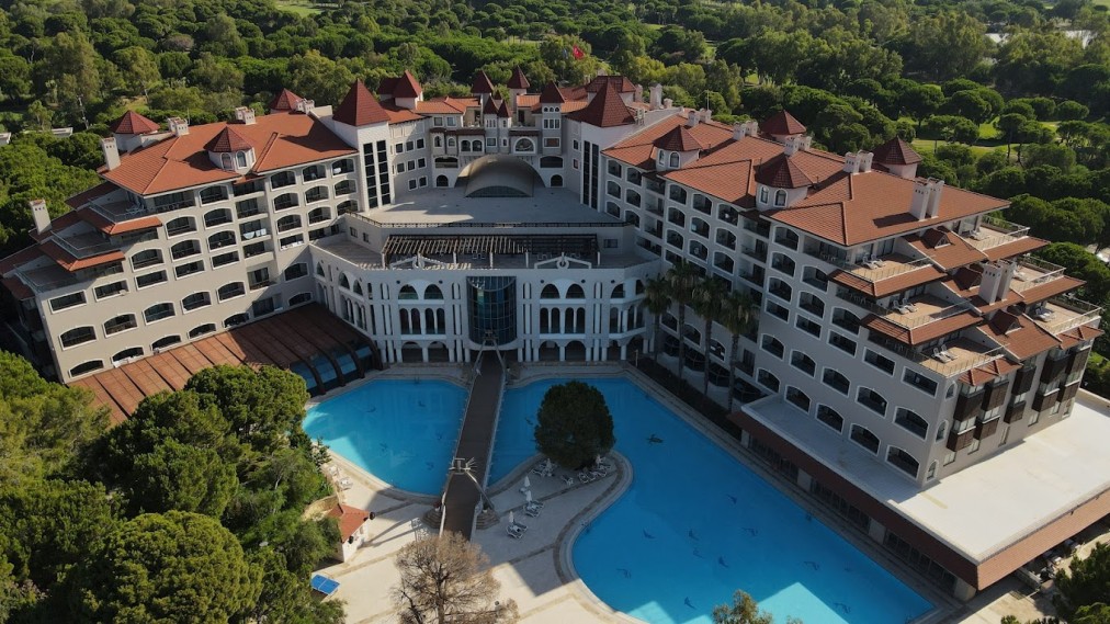 Aerial view of the resort complex with large outdoor pools and surrounding trees.