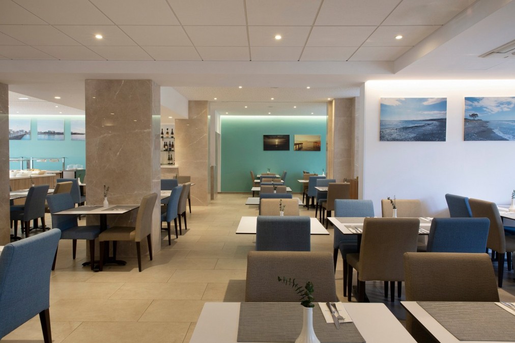 Modern restaurant with blue and beige chairs and light-colored decor