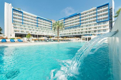 Pool and hotel exterior with fountain feature