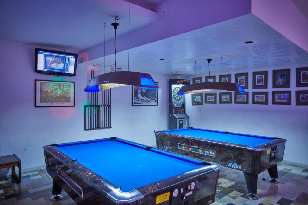 Games room with two pool tables, dartboard, and wall-mounted TV.