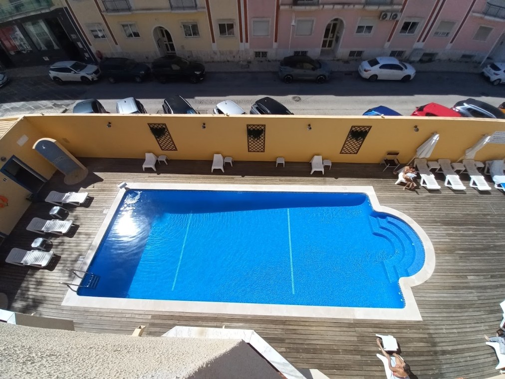 Outdoor pool and sun loungers in the hotel courtyard, viewed from above.
