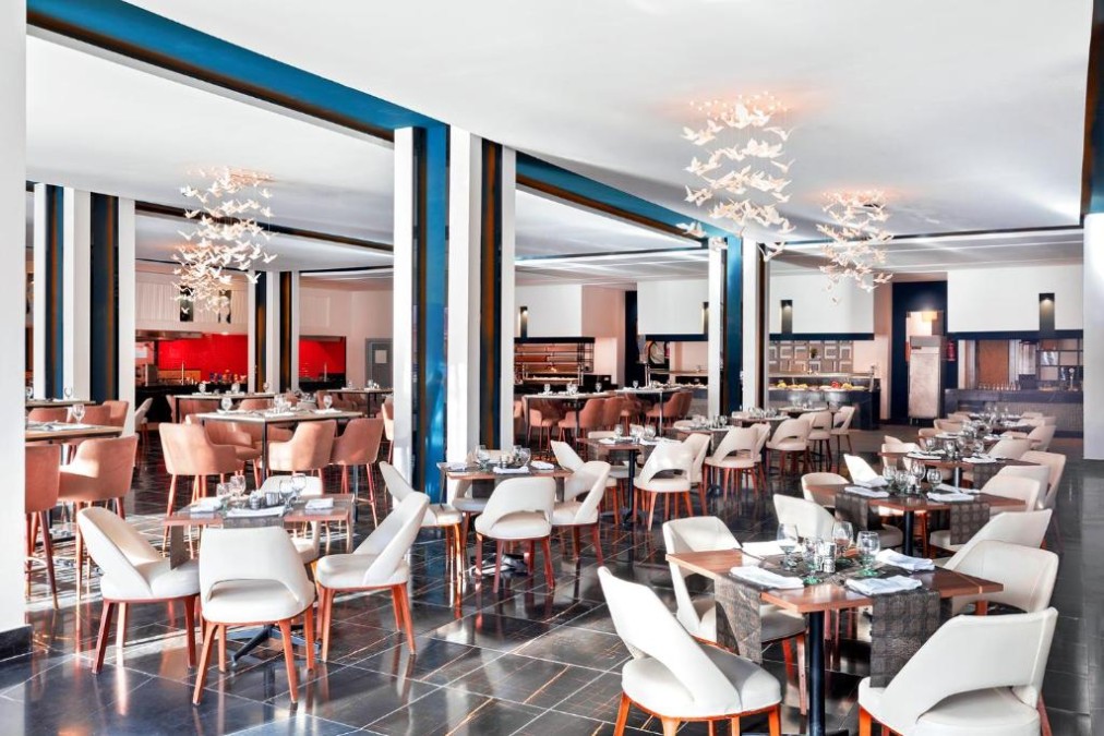 Modern restaurant with white chairs, brown accents, and decorative lighting
