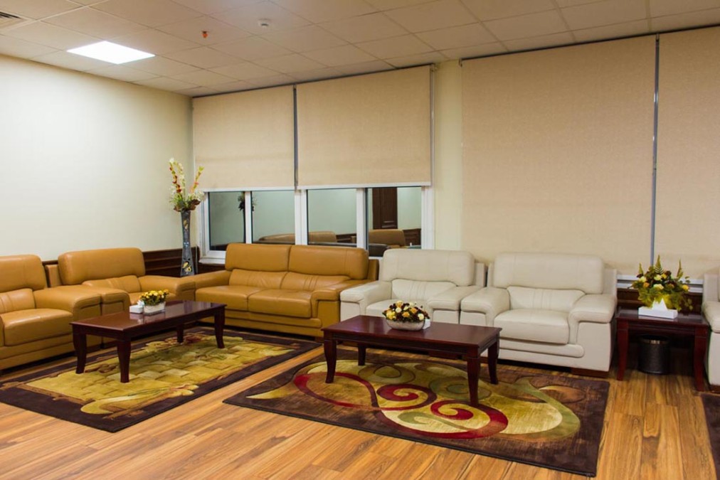 Indoor lounge with leather sofas, coffee tables, and patterned rugs.
