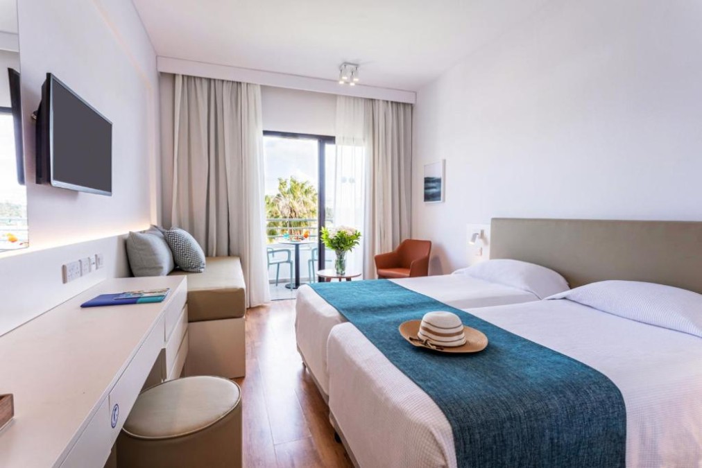Twin guest room with sofa, desk and balcony seating.