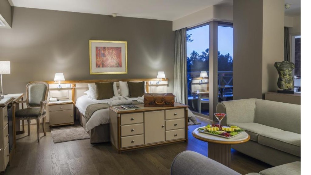 Spacious guest room with double bed, seating area and balcony access.