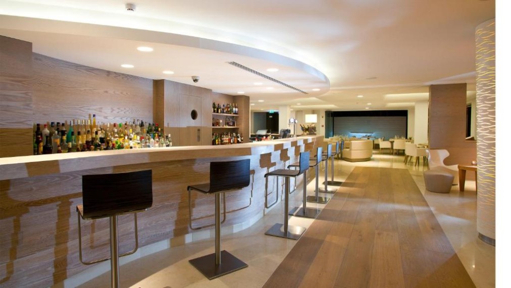 Hotel bar with counter seating and lounge area.