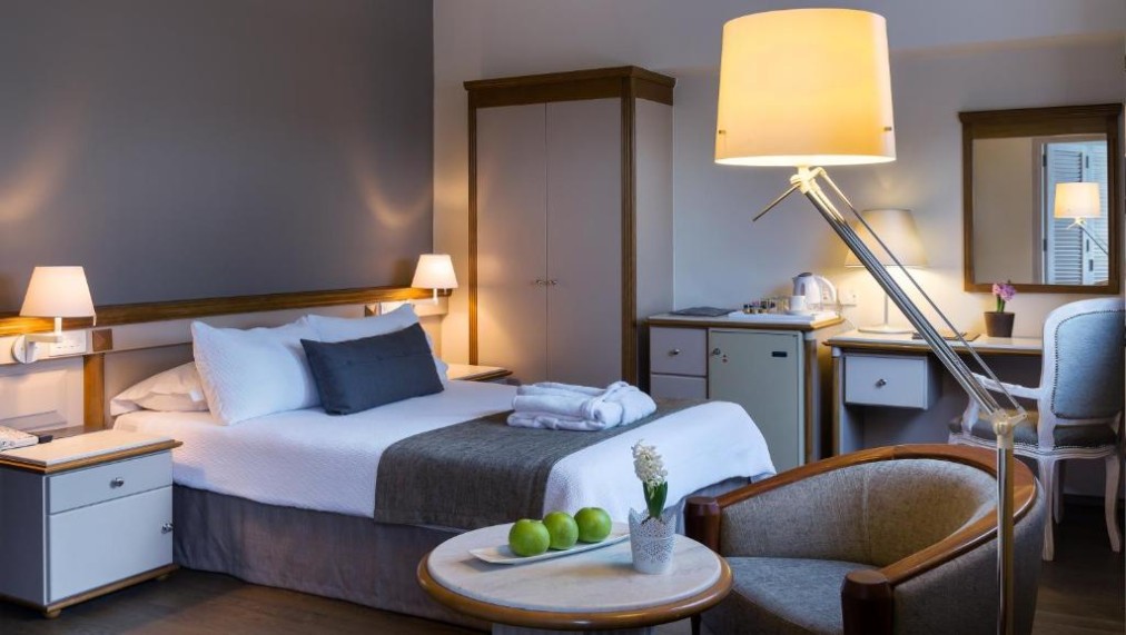 Guest room with double bed, desk, wardrobe and minibar.