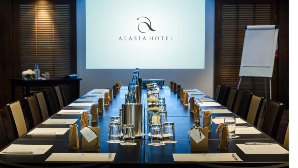 Conference room with long board table, projector screen and meeting setup.
