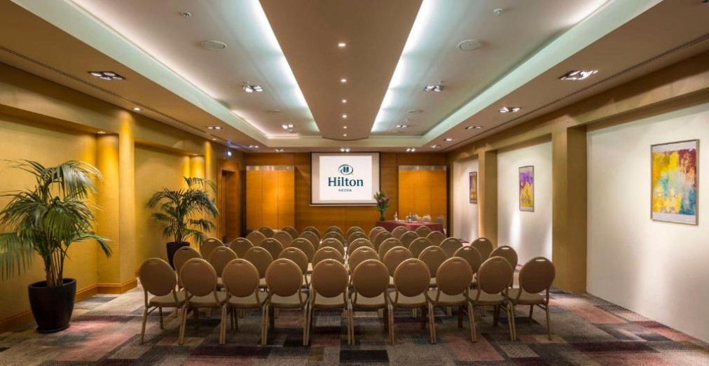 Conference room with theater seating and presentation screen.