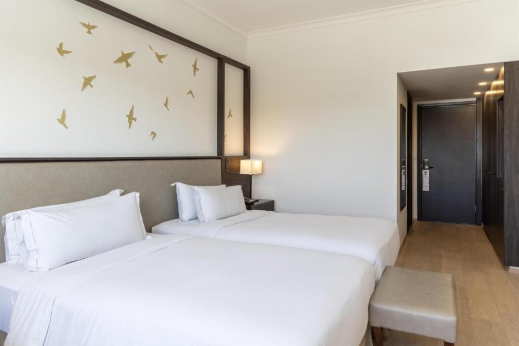 Twin guest room with bench seating and wardrobe by the entrance.