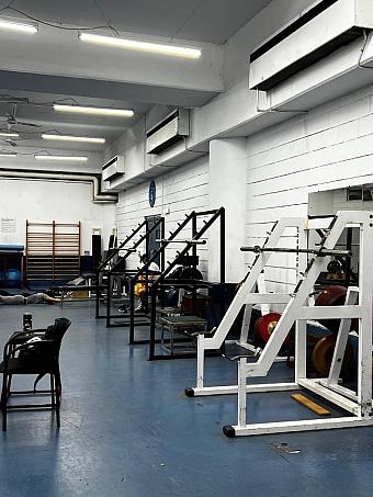Fitnessbereich mit Hebeausrüstung und Racks, genutzt für Athletiktraining und Coaching-Einheiten